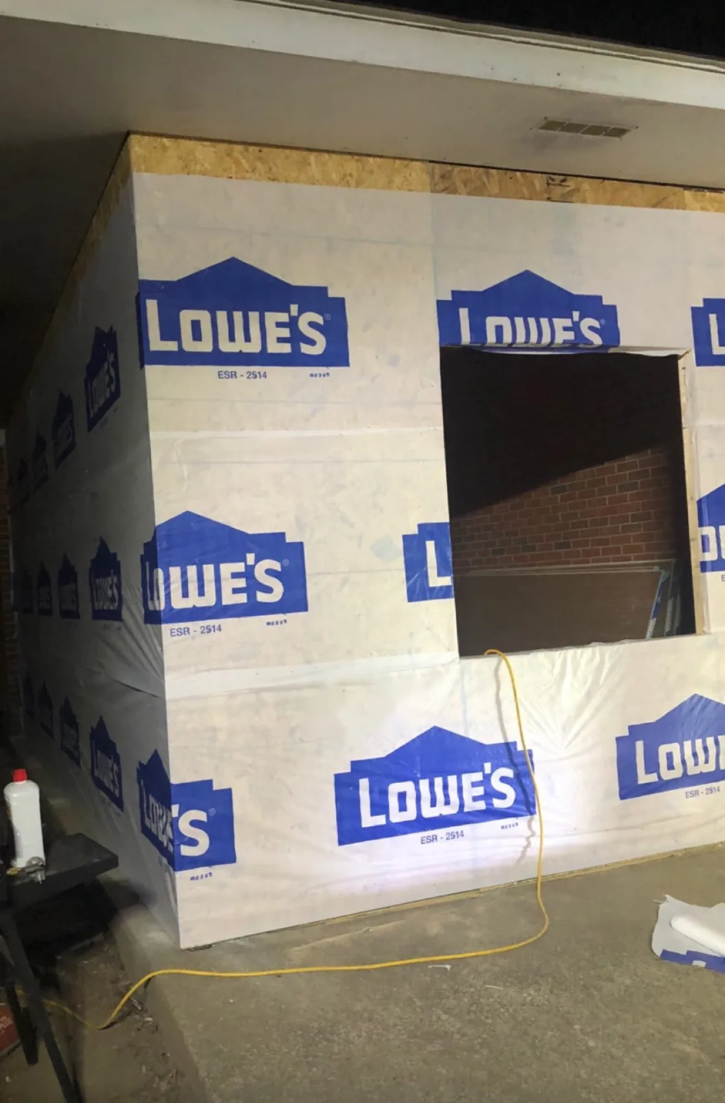 New addition framed and covered in house wrap, photographed at night